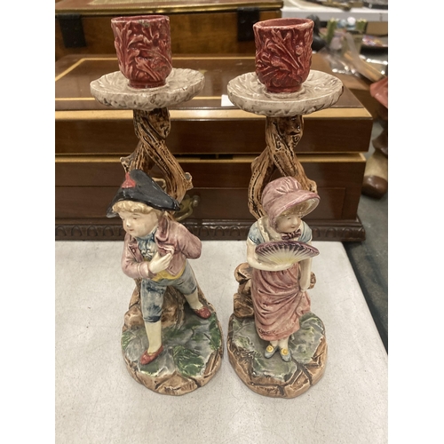 252 - A PAIR OF CERAMIC CANDLE HOLDERS DEPICTING A BOY AND A GIRL