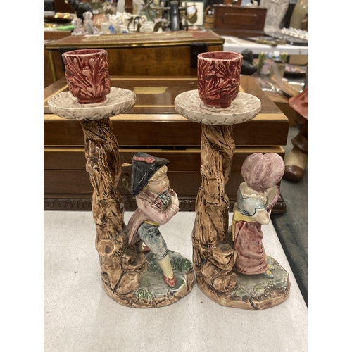 252 - A PAIR OF CERAMIC CANDLE HOLDERS DEPICTING A BOY AND A GIRL