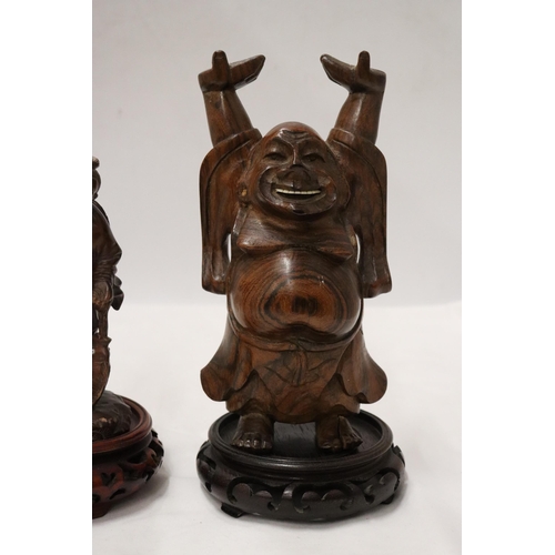 176 - TWO CARVED WOODEN ORIENTAL FIGURES TO INCLUDE A LAUGHING BUDDAH, ON STANDS