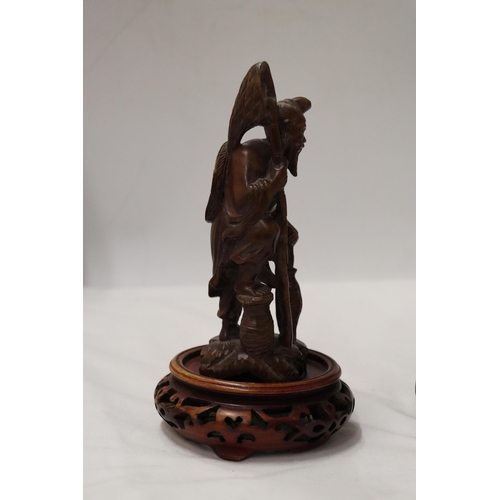 176 - TWO CARVED WOODEN ORIENTAL FIGURES TO INCLUDE A LAUGHING BUDDAH, ON STANDS