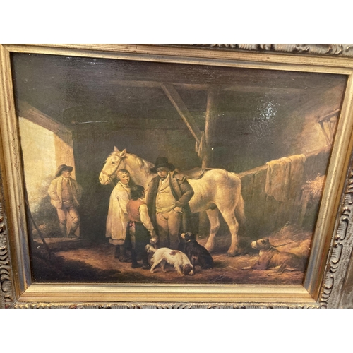 21 - A GILT FRAMED PRINT OF A FAMILY AND DOGS IN A STABLE WITH A HORSE 17CM X 22CM