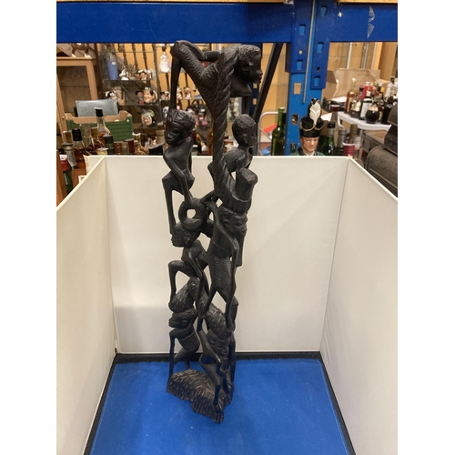 59 - A HEAVILY CARVED AFRICAN EBONY FIGURE APPROX 56CM TALL