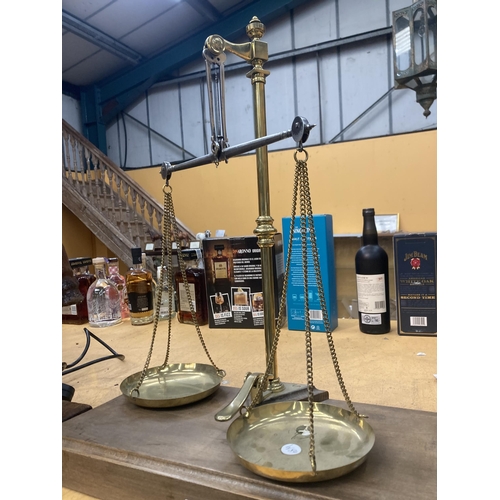 62 - A SET OF BRASS BALANCE SCALES ON A WOODEN BASE