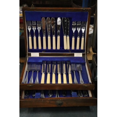 1005 - A VINTAGE CANTEEN OF CUTLERY IN A MAHOGANY CASE WITH BOTTOM DRAWER