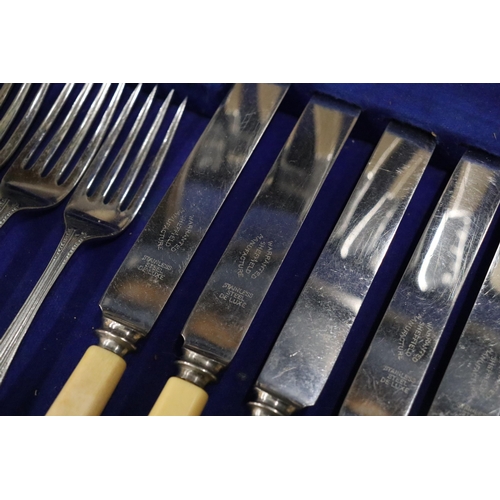 1005 - A VINTAGE CANTEEN OF CUTLERY IN A MAHOGANY CASE WITH BOTTOM DRAWER