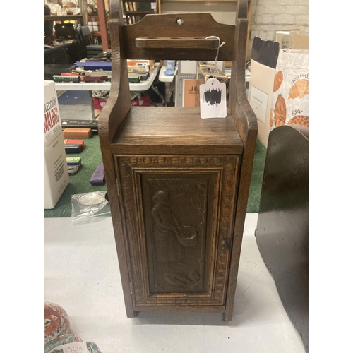 110A - A VINTAGE OAK SMOKERS CABINET WITH CARVED DOOR