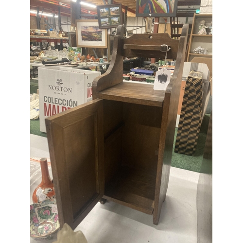 110A - A VINTAGE OAK SMOKERS CABINET WITH CARVED DOOR