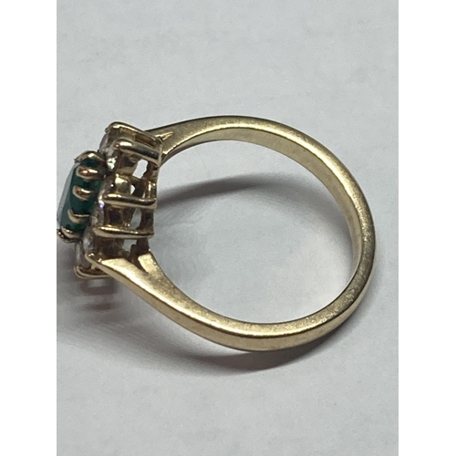 699 - A 9 CARAT GOLD RING WITH A CENTRE EMERALD SURROUNDED BY CUBIC ZIRCONIAS SIZE L