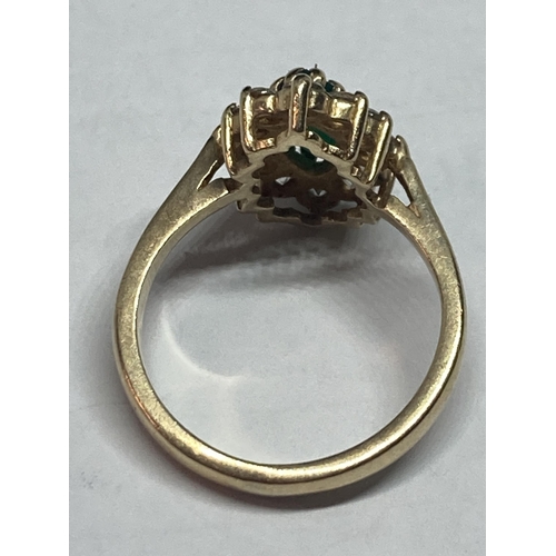 699 - A 9 CARAT GOLD RING WITH A CENTRE EMERALD SURROUNDED BY CUBIC ZIRCONIAS SIZE L