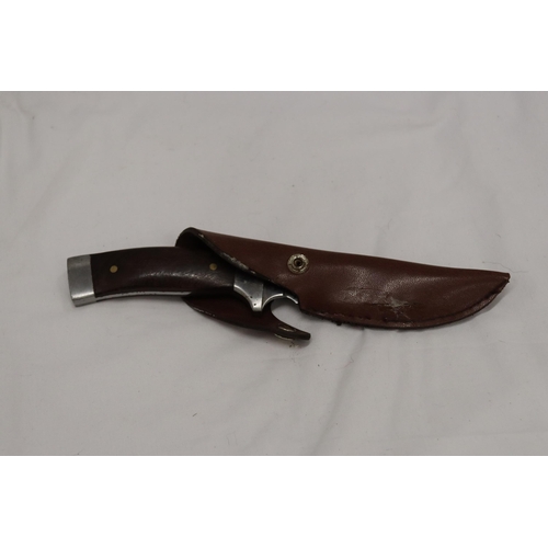 975 - A HUNTING KNIFE IN A LEATHER SHEATH