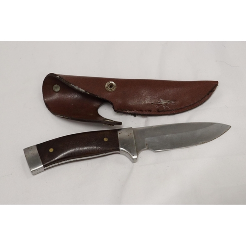 975 - A HUNTING KNIFE IN A LEATHER SHEATH