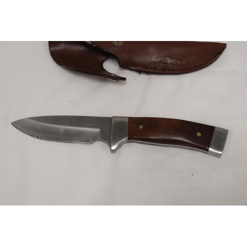 975 - A HUNTING KNIFE IN A LEATHER SHEATH