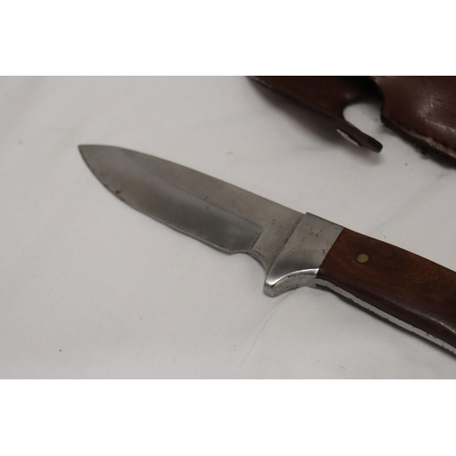 975 - A HUNTING KNIFE IN A LEATHER SHEATH