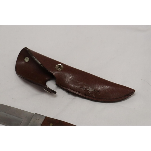 975 - A HUNTING KNIFE IN A LEATHER SHEATH