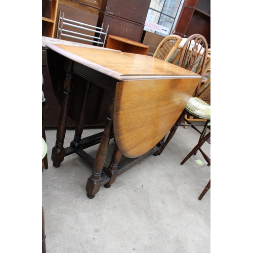 2669 - AN OVAL OAK GATELEG DINING TABLE AND FOUR ERCOL STYLE WINDSOR CHAIRS