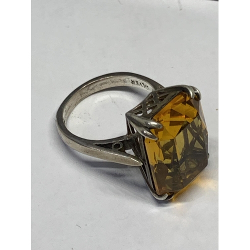 521 - A SILVER AND YELLOW STONE RING IN A PRESENTATION BOX