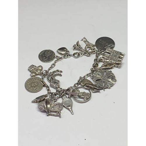 526 - A SILVER CHARM BRACELET WITH NINETEEN CHARMS