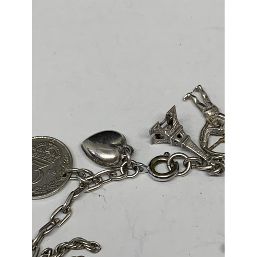 526 - A SILVER CHARM BRACELET WITH NINETEEN CHARMS