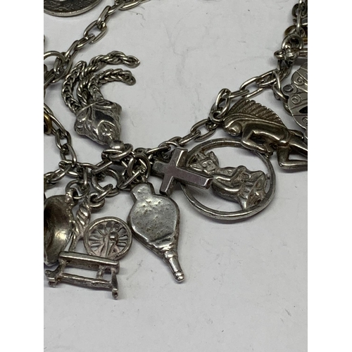 526 - A SILVER CHARM BRACELET WITH NINETEEN CHARMS