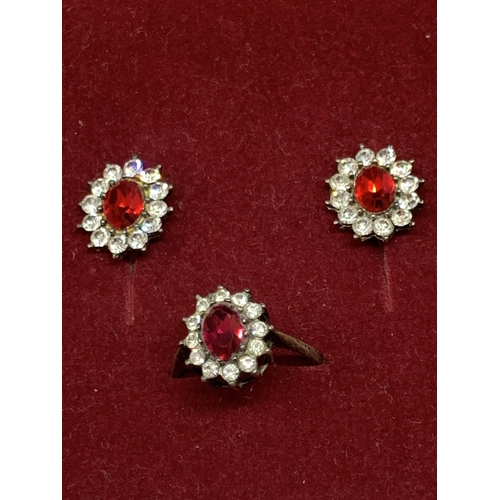 548 - A SILVER RED STONE RING AND EARRINGS IN A PRESENTATION BOX