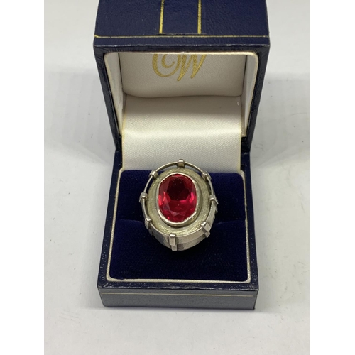 552 - AN OVAL DESIGNER RING WITH RED STONE IN A PRESENTATION BOX