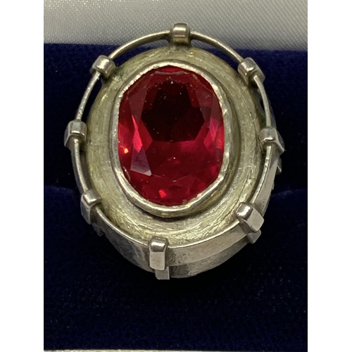 552 - AN OVAL DESIGNER RING WITH RED STONE IN A PRESENTATION BOX