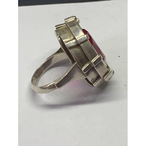 552 - AN OVAL DESIGNER RING WITH RED STONE IN A PRESENTATION BOX