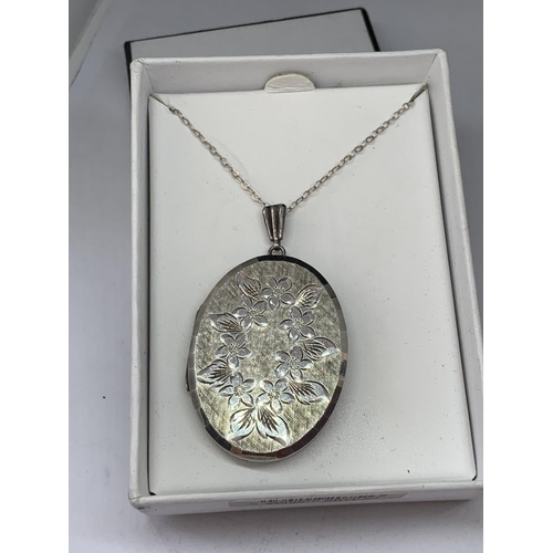 587 - A SILVER OVAL LOCKET IN A PRESENTATION BOX