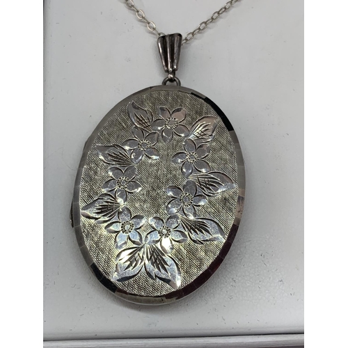 587 - A SILVER OVAL LOCKET IN A PRESENTATION BOX