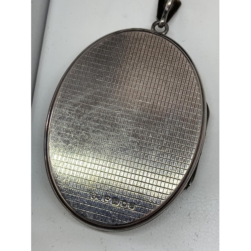 587 - A SILVER OVAL LOCKET IN A PRESENTATION BOX