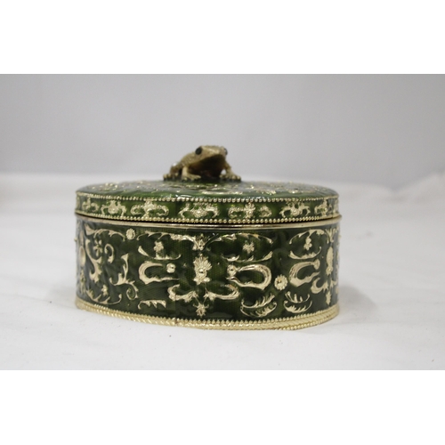 110 - A GREEN ENAMELLED KEEPSAKE/JEWELLERY BOX WITH A JEWELLED FRONG ON THE LID, HEIGHT 8CM, DIAMETER, 16C... 