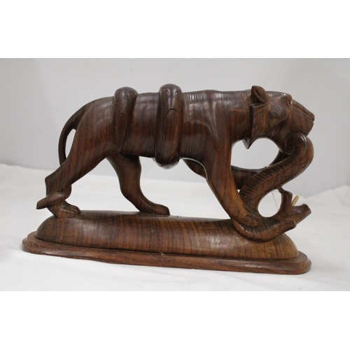 139 - A CARVED WOODEN BIG CAT WITH A SNAKE, HEIGHT 17CM, LENGTH 28CM