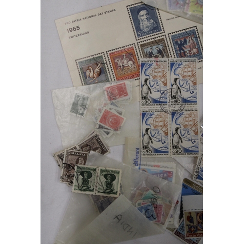 438 - A QUANTITY OF STAMPS IN PACKETS FROM AROUND THE WORLD