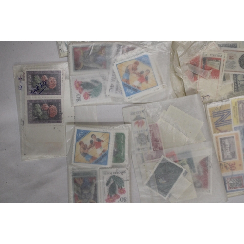 439 - A QUANTITY OF STAMPS IN PACKETS FROM AROUND THE WOR4LD