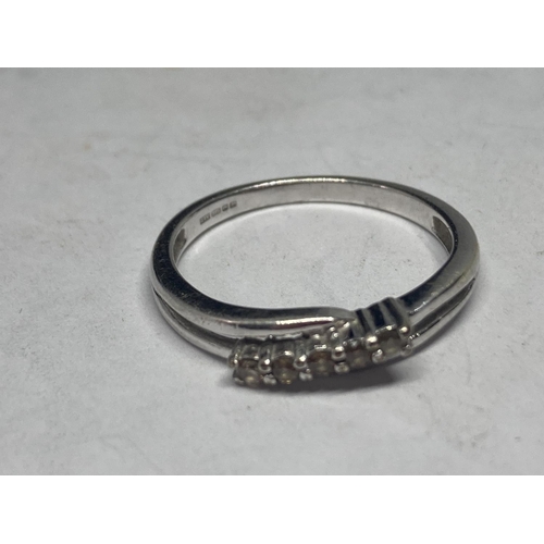 516 - A 9 CARAT WHITE GOLD RING WITH FIVE IN LINE STONES SIZE N