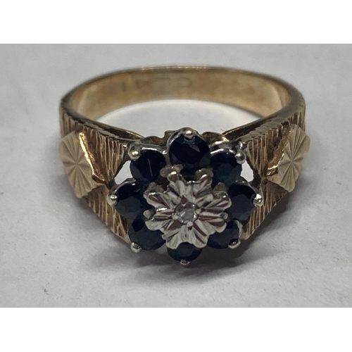 517 - A 9 CARAT GOLD RING WITH CENTRE DIAMOND SURROUNDED BY SAPPHIRES SIZE J