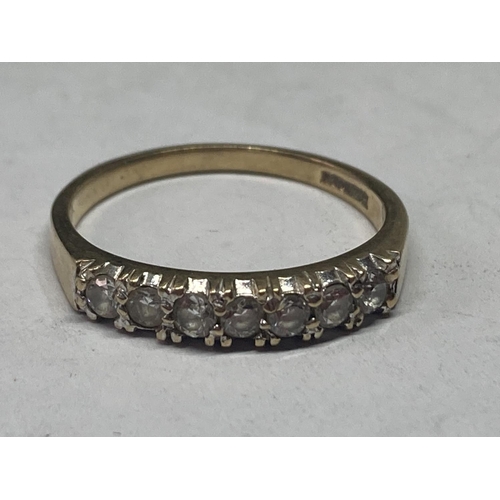 518 - A 9 CARAT GOLD RING WITH SEVEN IN LINE CUBIC ZIRCONIAS SIZE Q/R