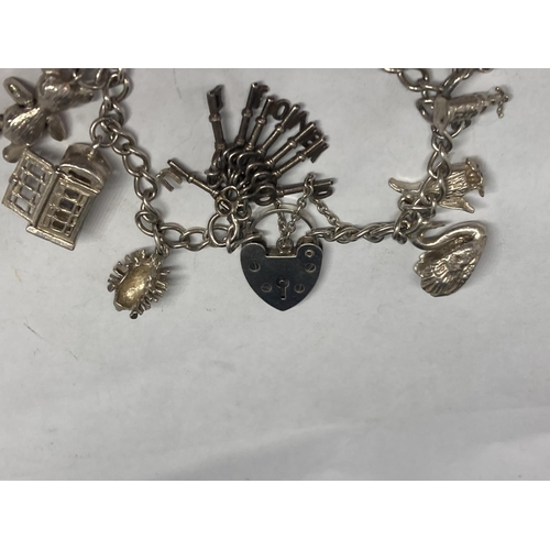 631 - A SILVER CHARM BRACELET WITH FOURTEEN CHARMS