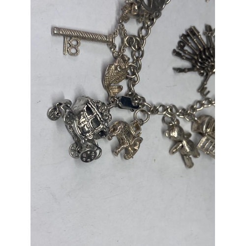 631 - A SILVER CHARM BRACELET WITH FOURTEEN CHARMS