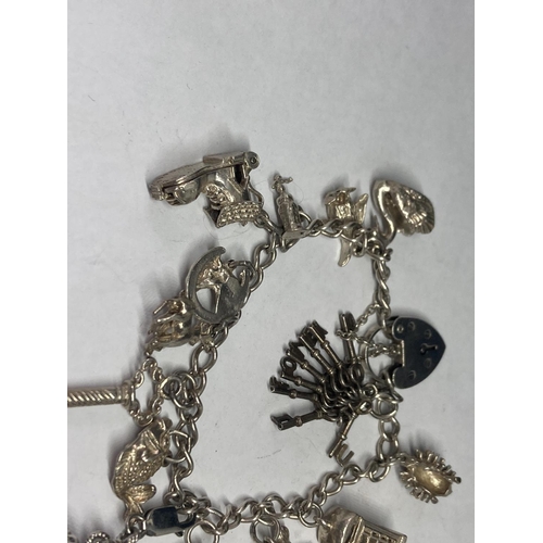 631 - A SILVER CHARM BRACELET WITH FOURTEEN CHARMS