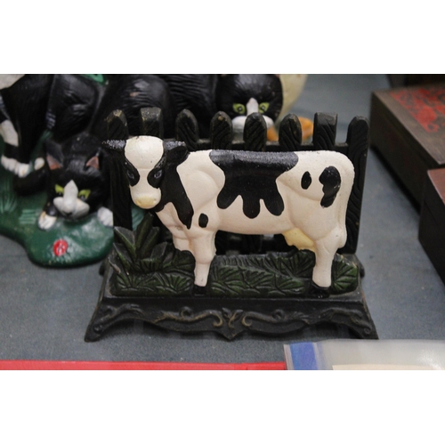 193 - THREE CAST IRON ITEMS TO INCLUDE A LETTER RACK WITH COW DECORATION, PLUS DUCK AND CAT DOOR STOPS