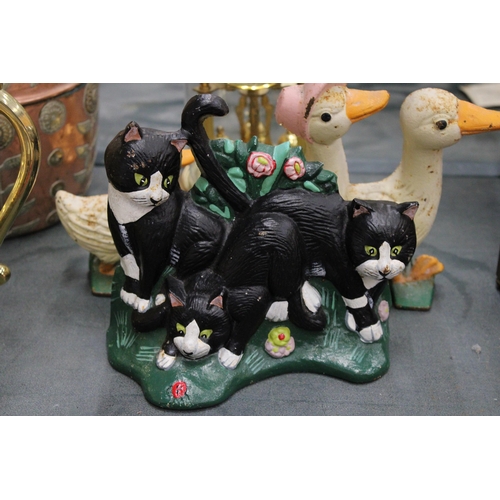 193 - THREE CAST IRON ITEMS TO INCLUDE A LETTER RACK WITH COW DECORATION, PLUS DUCK AND CAT DOOR STOPS