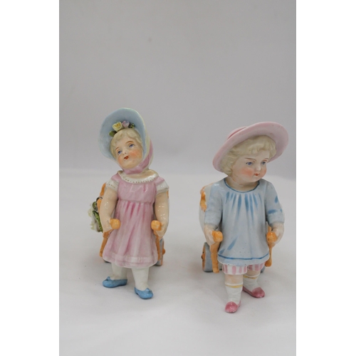 236 - TWO VINTAGE CONTA AND BOHME GERMAN FAIRINGS TO INCLUDE TWO GIRLS PULLING FLOWER CARTS, ONE WITH A HA... 