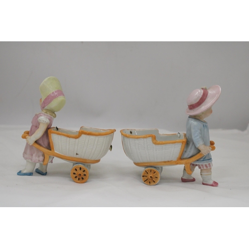 236 - TWO VINTAGE CONTA AND BOHME GERMAN FAIRINGS TO INCLUDE TWO GIRLS PULLING FLOWER CARTS, ONE WITH A HA... 