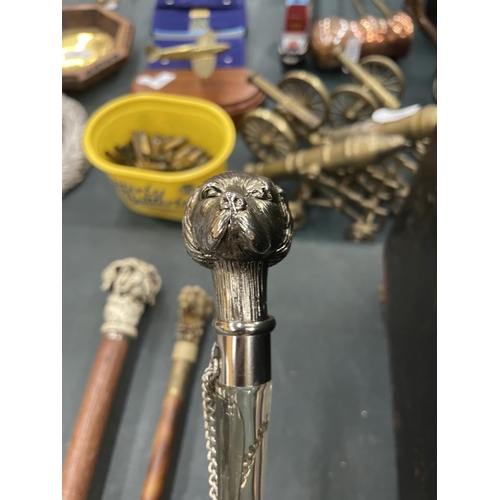 98A - TWO CARVED DOG HEAD WALKING STICKS AND A WHITE METAL DOG HEAD SHOE HORN