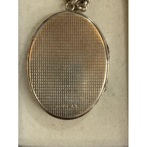 562 - A SILVER OVAL LOCKET IN A PRESENTATION BOX