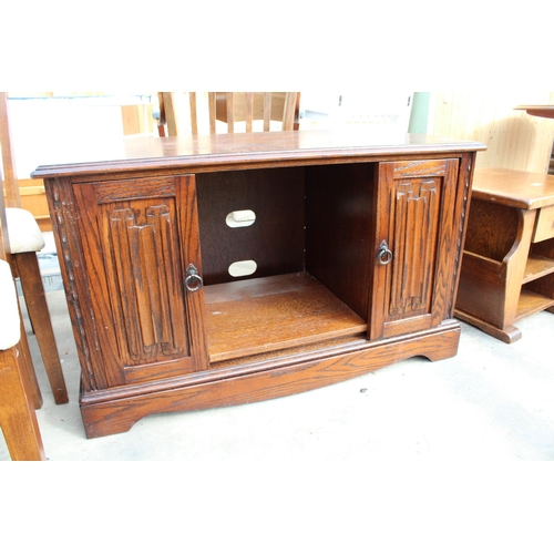 2850 - AN OAK MAGAZINE RACK / TABLE AND OAK JAYCEE TELEVISION STAND WITH LINENFOLD SLIDING DOORS