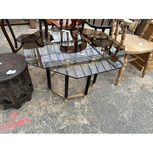 2899 - A RETRO OCTAGONAL SMOKED GLASS COFFEE TABLE ON BLACK AND BRASS EFFECT BASE