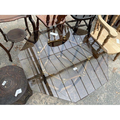 2899 - A RETRO OCTAGONAL SMOKED GLASS COFFEE TABLE ON BLACK AND BRASS EFFECT BASE