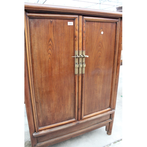 3022 - A CHINESE ELM TAPERING TWO DOOR CABINET WITH BRASS HANDLES AND LOCK WITH TWO INTERNAL DRAWERS, 36